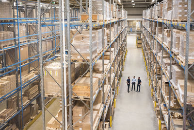 Businessman with colleagues having discussion in warehouse