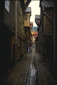 People walking on footpath amidst buildings in city