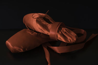Close-up of red ballet shoes over black background