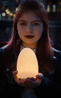 Night lamp in the hands of a girl.