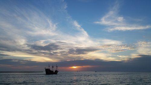 Silhouette boat sailing on sea against sky during sunset