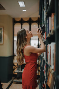 Side view of young woman standing in corridor