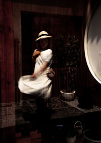 Rear view of woman standing against the wall