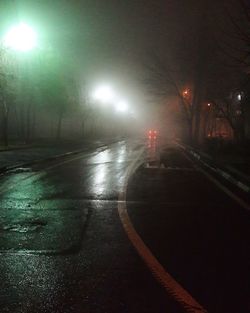 Illuminated road against sky at night