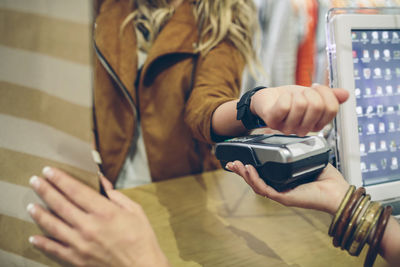 Woman paying using smartwatch with nfc technology in a store