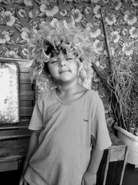 Portrait of girl standing against plants in yard