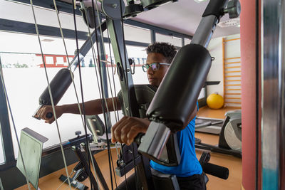 Black sportsman exercising on chest press machine