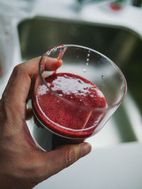 Close-up of hand holding red drink