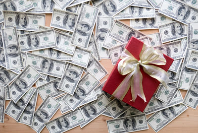 High angle view of gift box with paper currencies on table