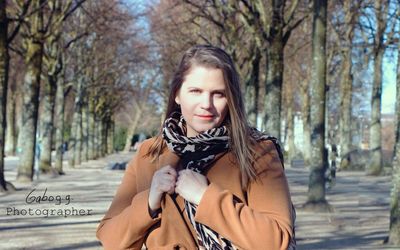 Portrait of smiling young woman against trees