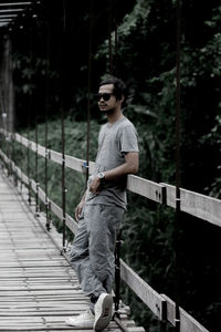 Man standing on footbridge