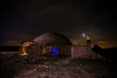 Man standing on field against sky at night