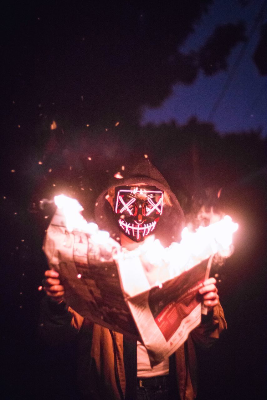 DIGITAL COMPOSITE IMAGE OF MAN HOLDING LIT CANDLE