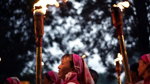 Portrait of woman holding fire against blurred background