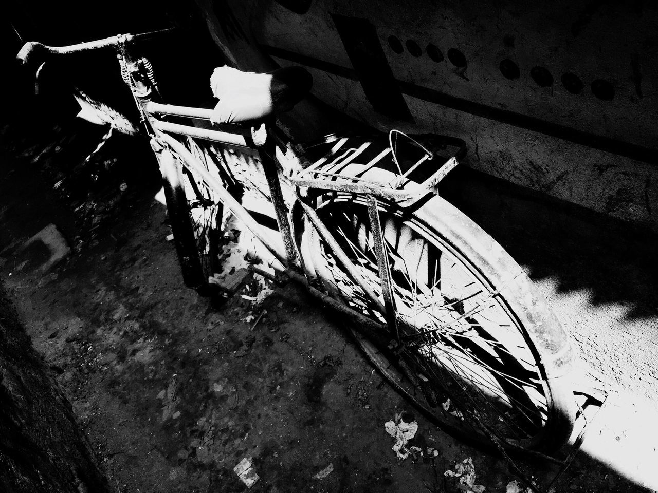 bicycle, transportation, mode of transport, abandoned, land vehicle, street, wheel, shadow, outdoors, damaged, old, obsolete, sunlight, day, high angle view, stationary, built structure, wall - building feature, parking, deterioration