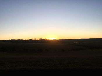 Scenic view of field against clear sky during sunset