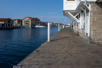View of wooden house by sea against sky
