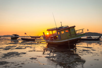 Ship moored on sea against sky during sunset