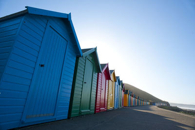 Row of colorful huts at beach on sunny day