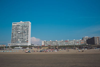 Buildings in city against clear blue sky