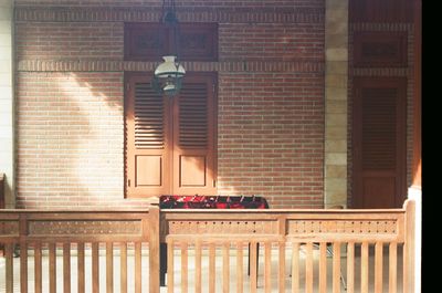 Empty chairs and table by window of building