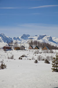 Scenic view of snow covered landscape and mountains against sky