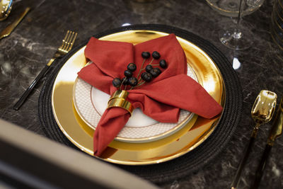 High angle view of napkin and fruit in plate on dining table