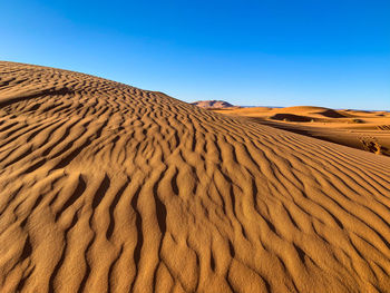 Sand dune in desert against clear sky