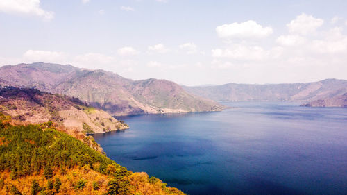 Scenic view of sea and mountains against sky