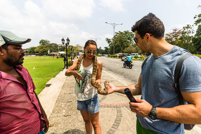 Young man holding people in city