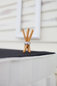 Close-up of breadstick and rings on table against white wall