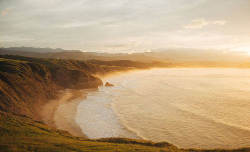 Scenic view of beach against sky during sunset