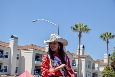 Portrait of young woman against clear sky