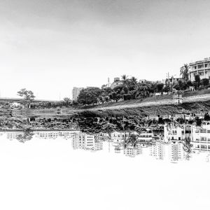 Reflection of buildings in calm water against sky