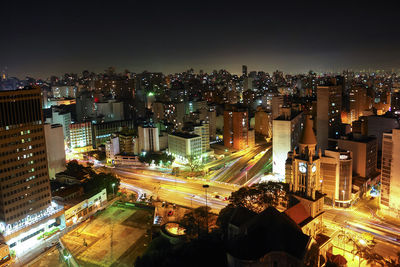 High angle view of illuminated city buildings against sky at night