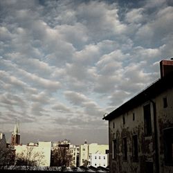 Buildings against cloudy sky