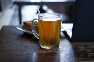 High angle view of drink by laptop on wooden table