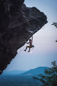 Man climbing overhanging sport climbing route in new hampshire