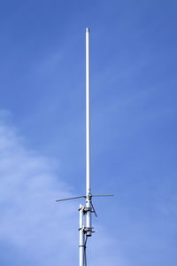 Low angle view of telephone pole against blue sky