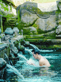 Man bathing in pond at temple