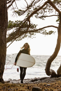 Woman with surfboard on beach