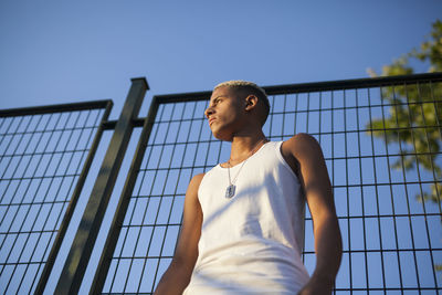 Portrait of young man standing against sky