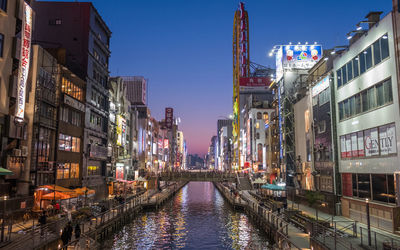 Panoramic view of canal amidst buildings against sky at night