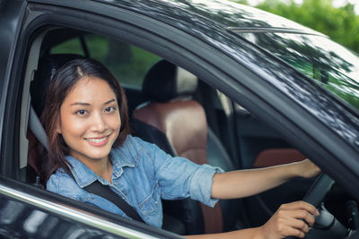 Portrait of smiling woman sitting in car