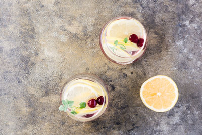 Summer refreshing cold cocktail with lemon, lemon balm and cherry - hard seltzer in glasses 