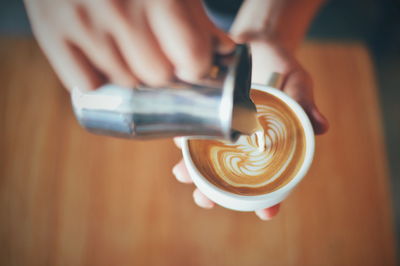 Cropped image of hand holding coffee cup