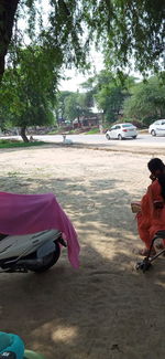 Rear view of people sitting on road