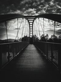 View of suspension bridge against cloudy sky