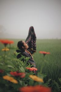 Rear view of man and woman on field against sky