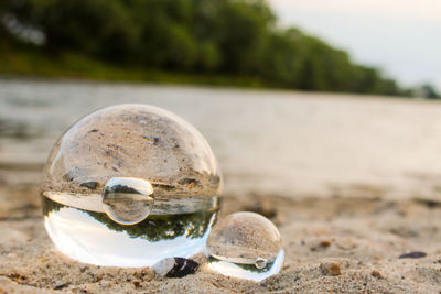 Close-up of crystal ball on beach